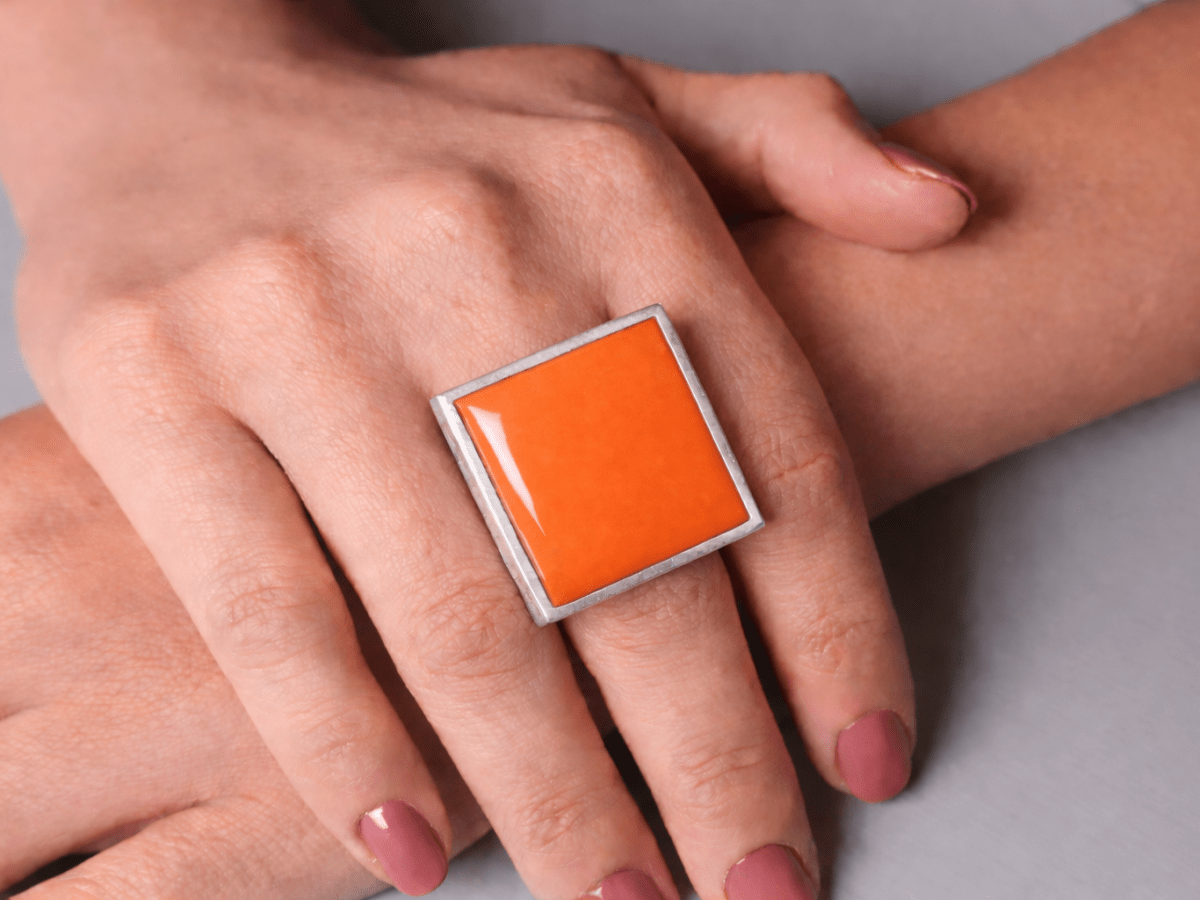 Models hands wearing a square orange ring