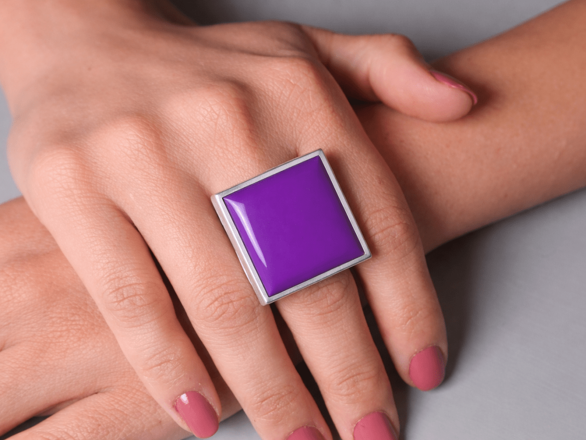 Models hands wearing a square purple ring