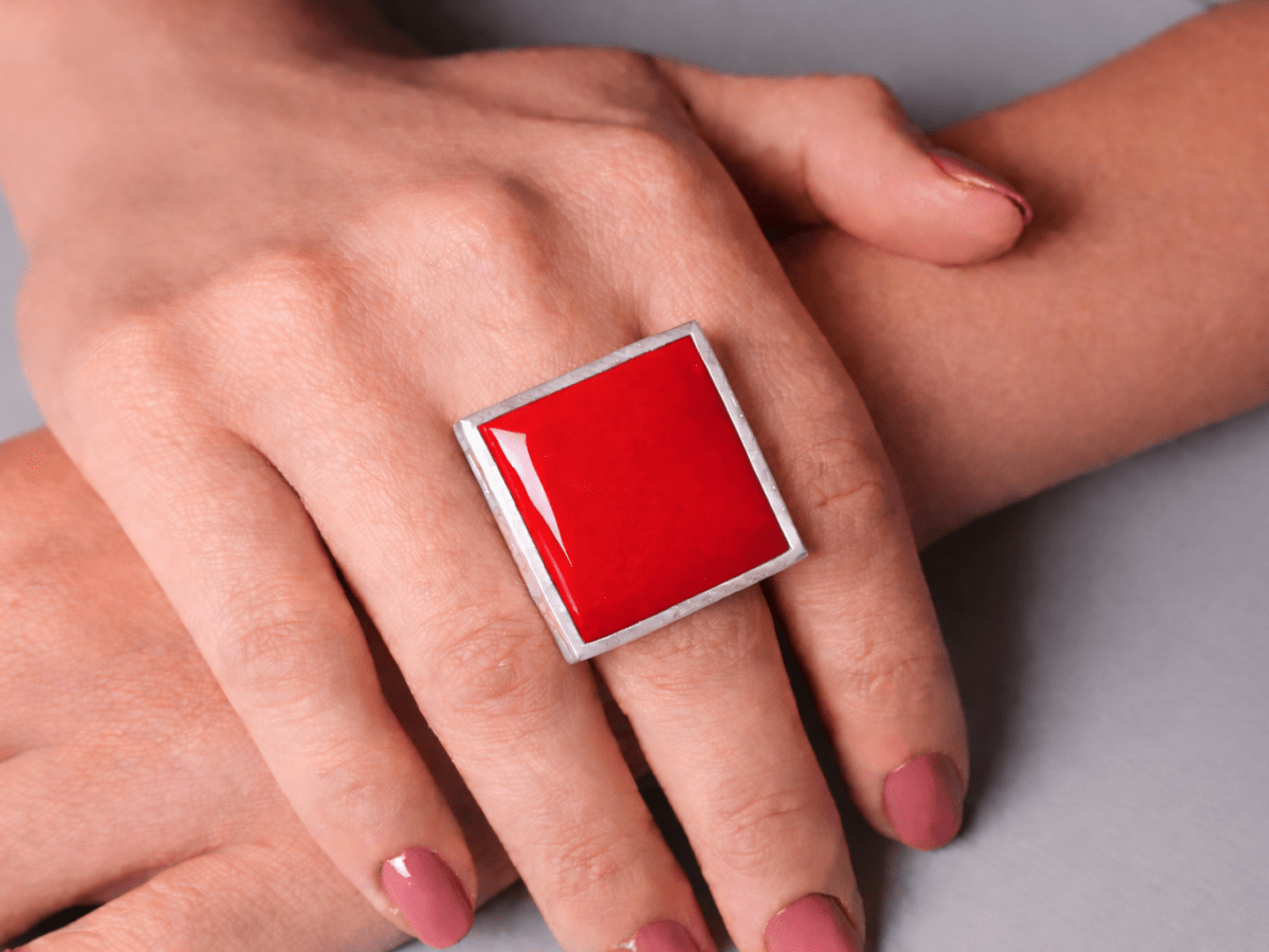 Models hands wearing a square red ring