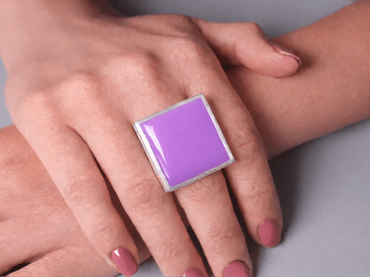 Models hands wearing a square violet ring