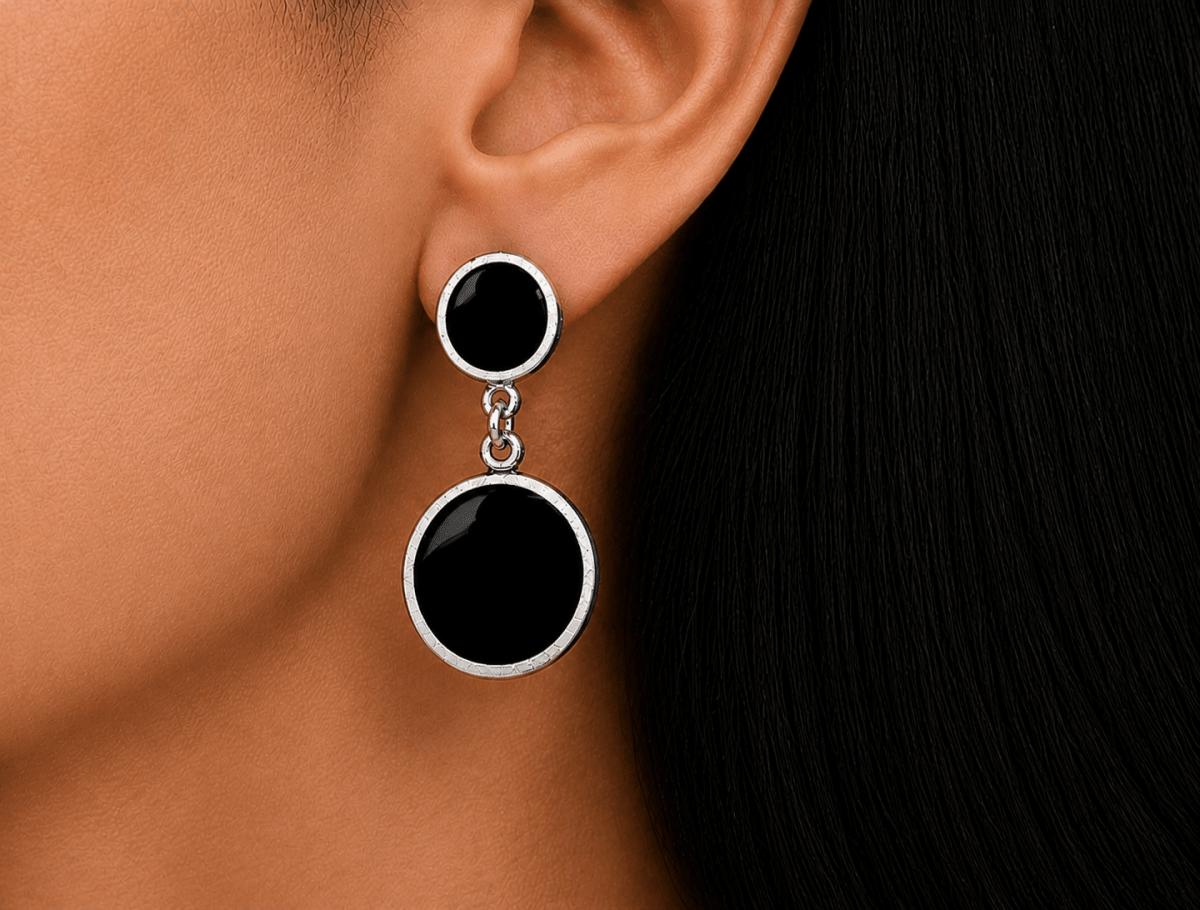 A model wearing some round black dangle drop earrings