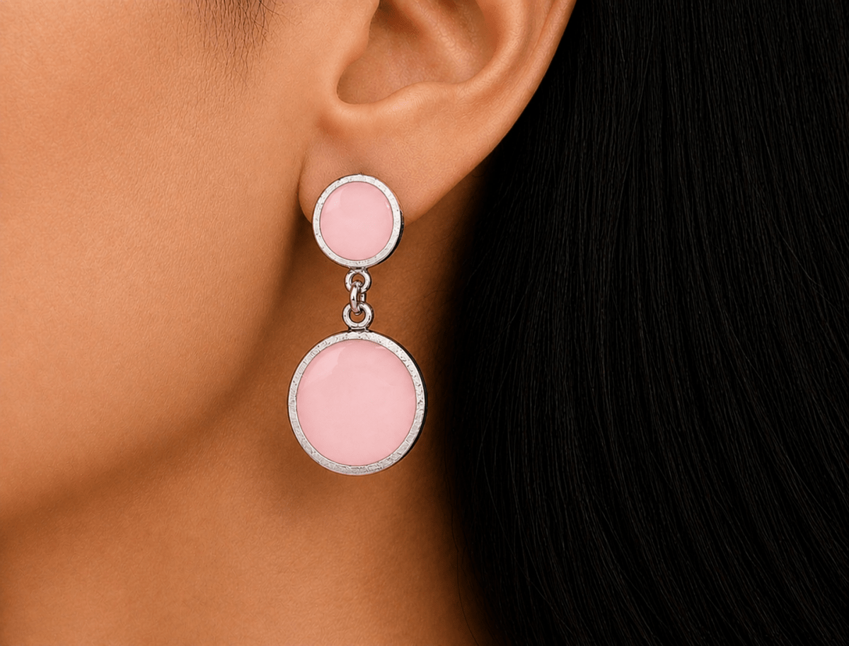A model wearing some round pale pink dangle drop earrings