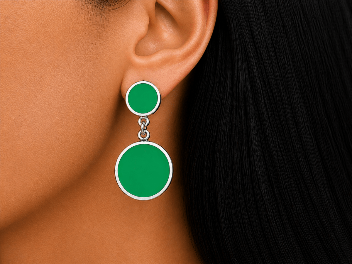 A model wearing some round green dangle drop earrings