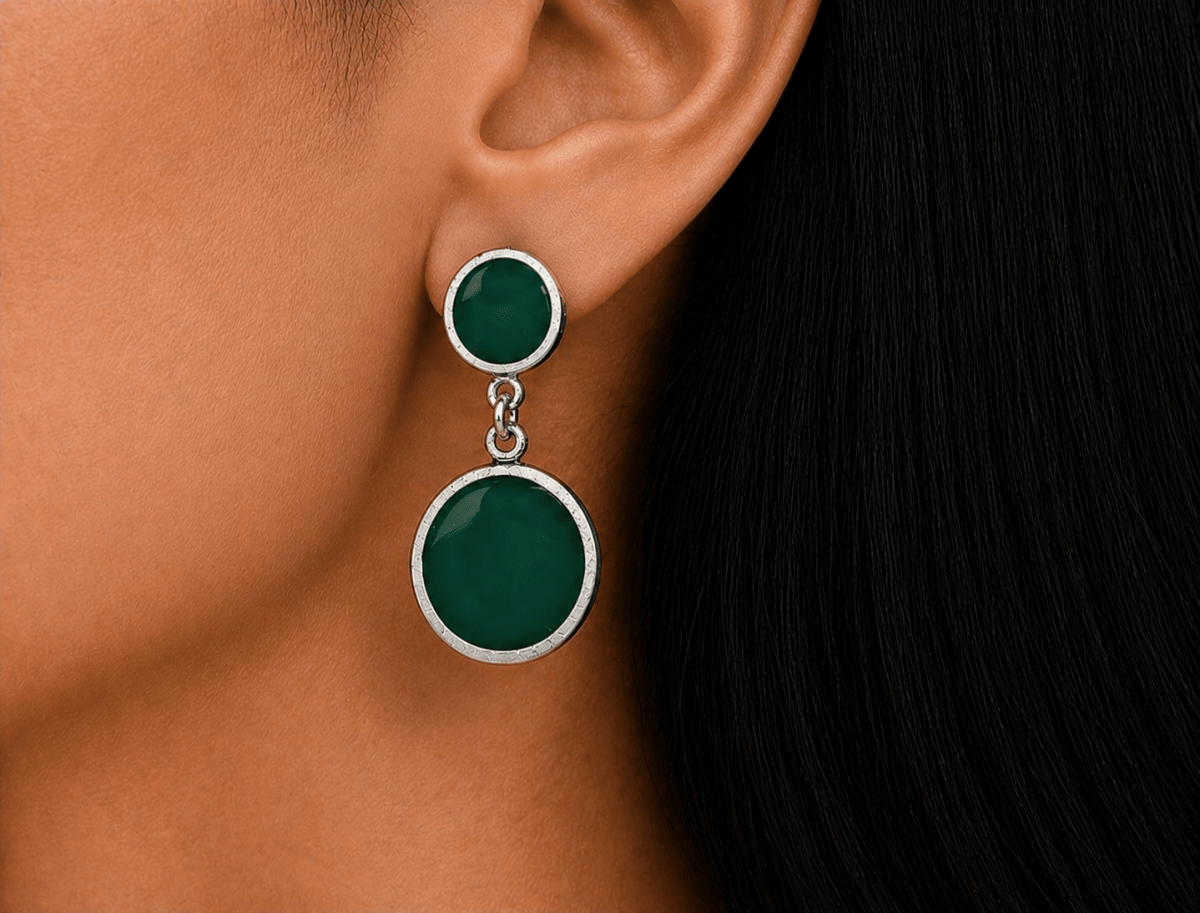 A model wearing some round green dangle drop earrings