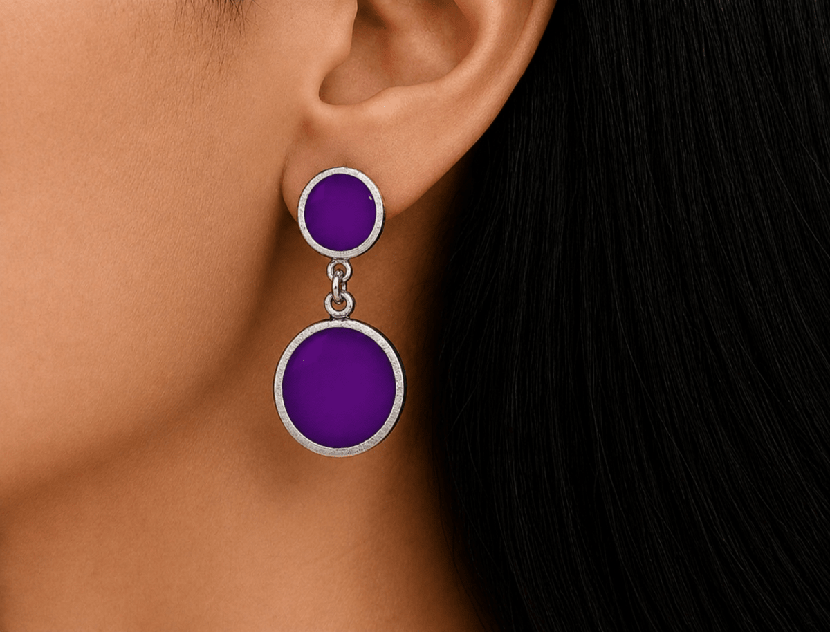 A model wearing some round purple dangle drop earrings