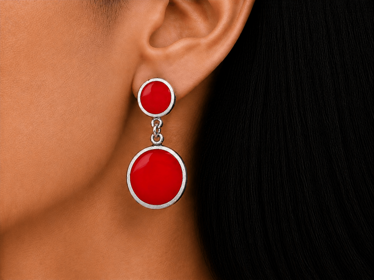 A model wearing some round bright red dangle drop earrings