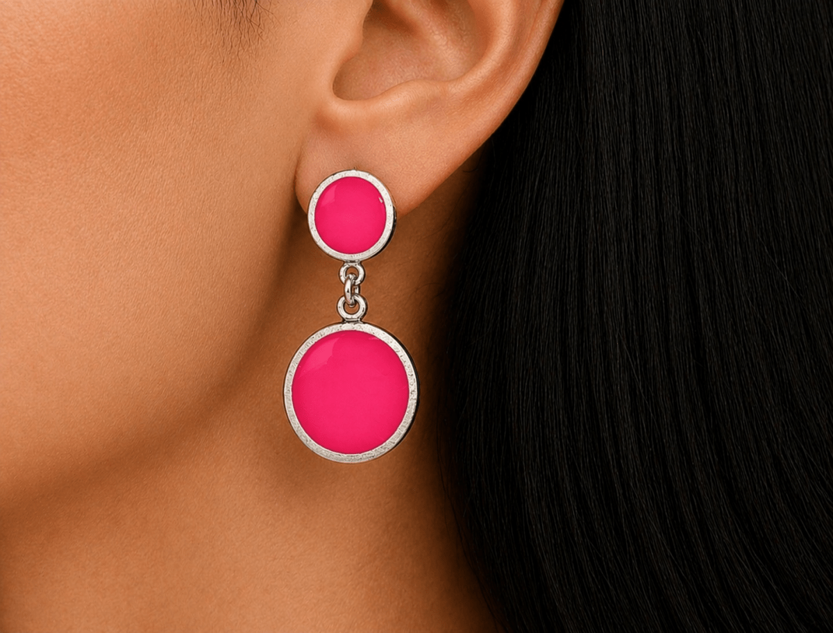 A model wearing some round deep pink dangle drop earrings