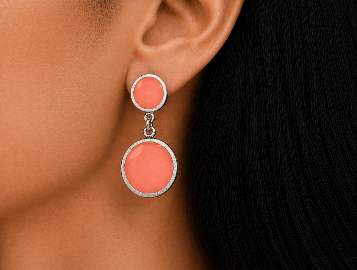 A model wearing some round salmon pink dangle drop earrings