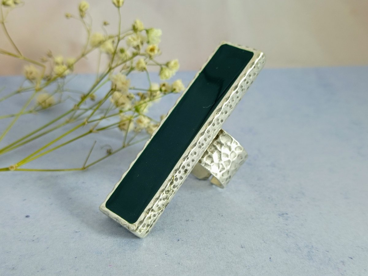 A long slim green ring with a silver band